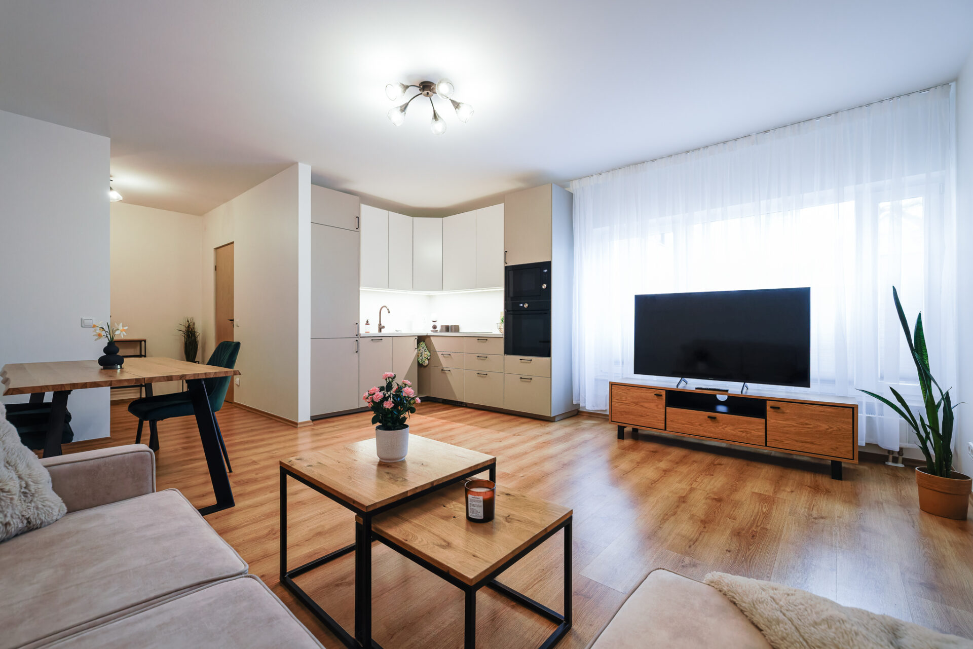 Bright living room with TV and modern kitchen at Kuressaare Stays apartment