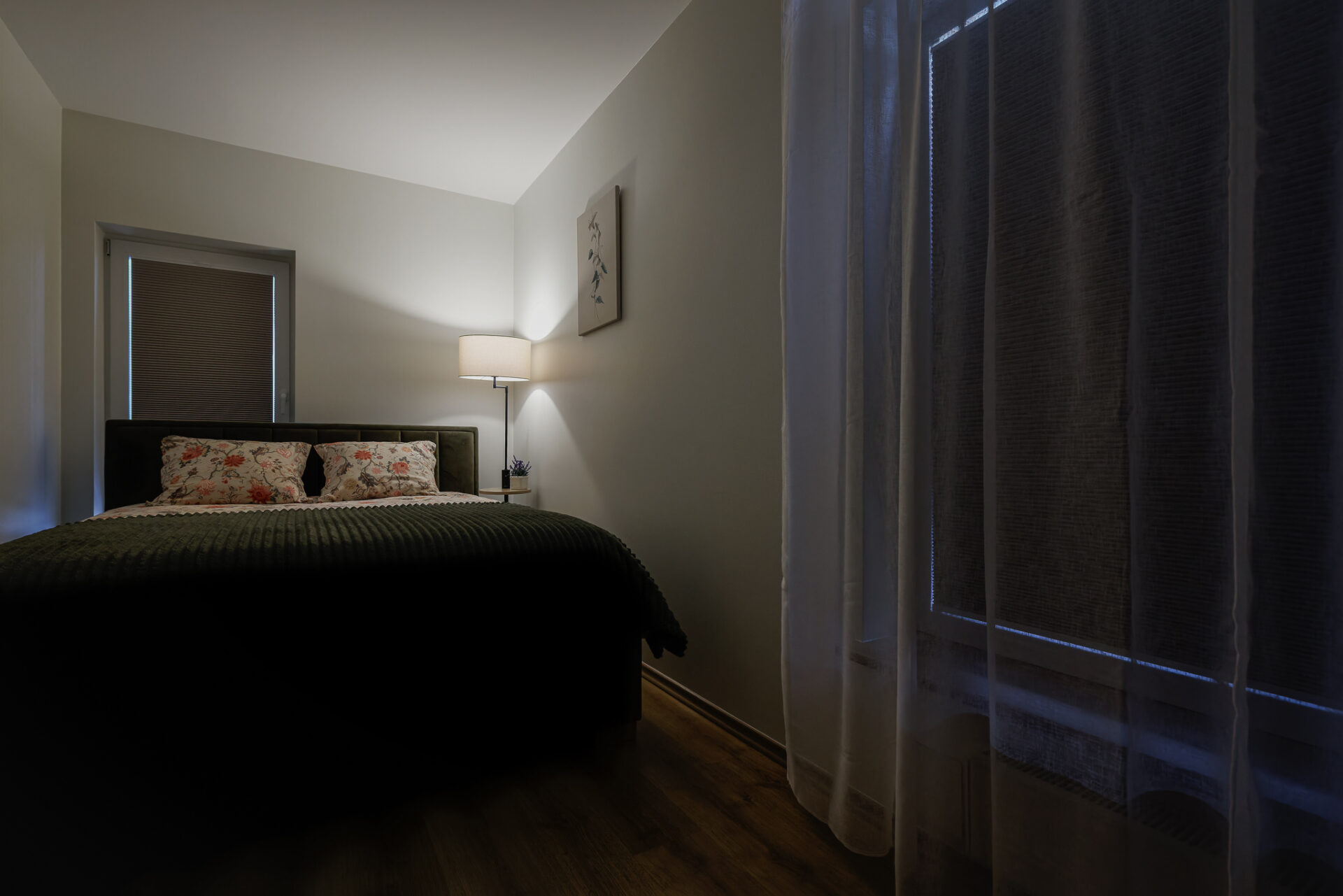 Cozy bedroom with warm evening lighting at Kuressaare Stays apartment